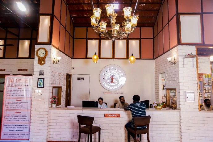 Front reception desk with staff welcoming individuals at Tapasya Health & Wellness Ayurveda centre, Kolhapur