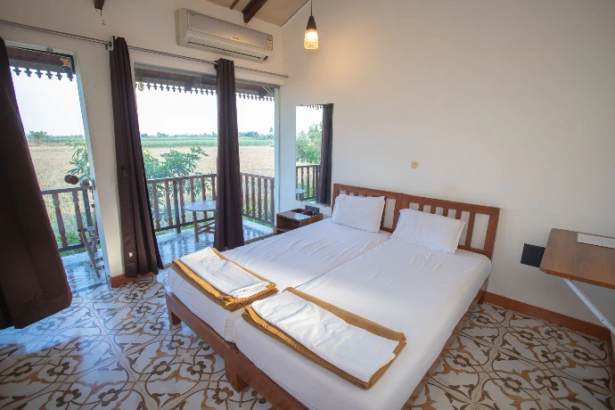 Comfortable twin-bed deluxe room with balcony and countryside view at Tapasya Health & Wellness