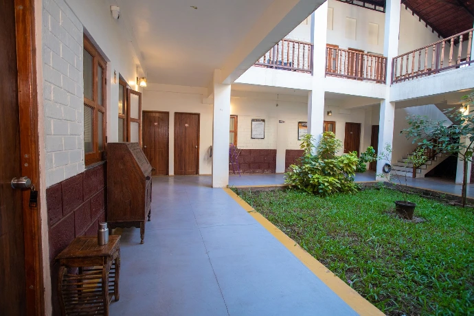Bright accommodation hallway opening to a green inner garden at Tapasya Health & Wellness