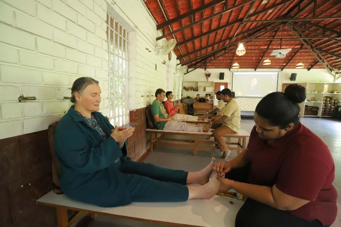 Therapist giving a guided foot and leg therapy session at Tapasya Health & Wellness