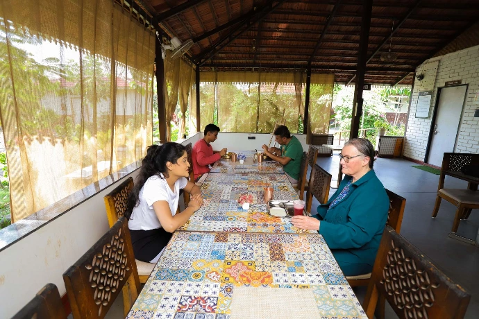 Individuals dining together at the communal Ayurvedic dining table at Tapasya Health & Wellness
