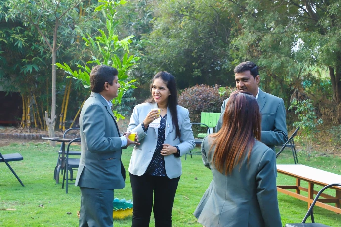 Corporate individuals networking in the garden during a wellness event at Tapasya Health & Wellness