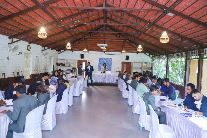 Large conference-style corporate wellness gathering in the event hall at Tapasya Health & Wellness
